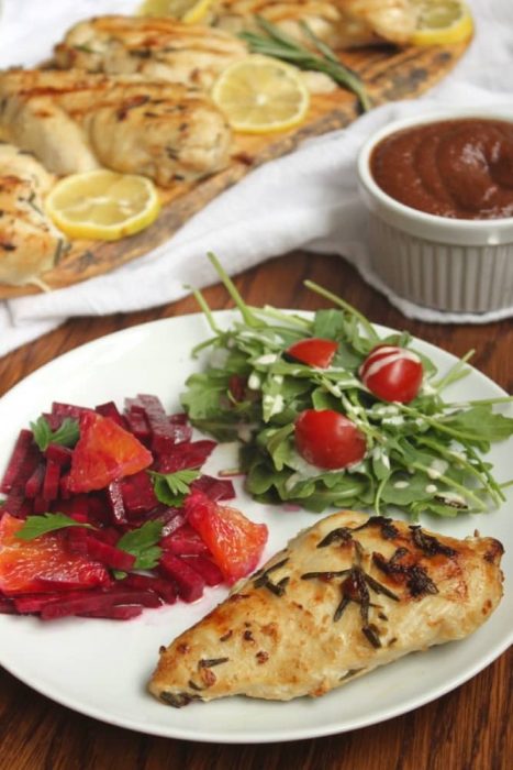whole30 compatible meal serving suggestion with grilled lemon rosemary chicken breasts.  Beet and orange salad with arugula and tomatoes