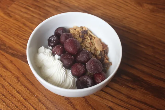 apricot maple pecan granola with frozen cherries and greek yogurt