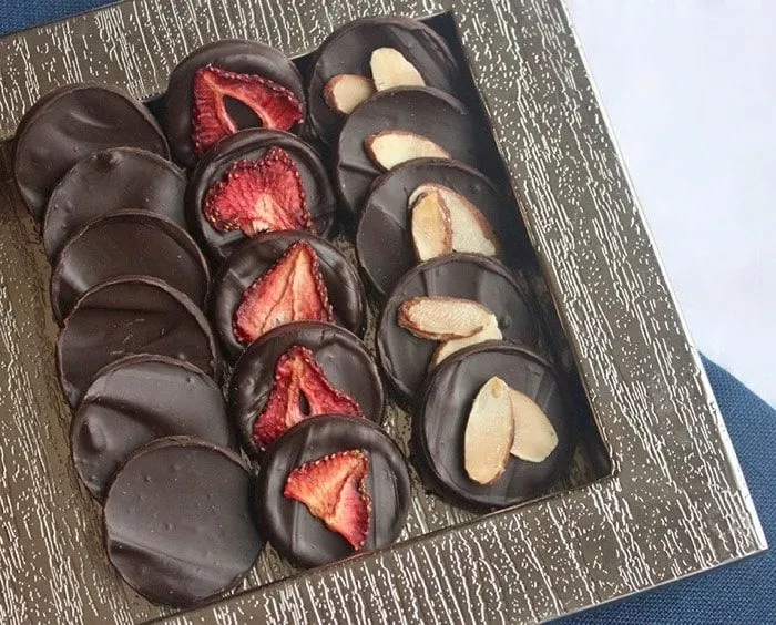 homemade dark chocolate coins with dried strawberries and toasted almonds are a delicious paleo holiday dessert