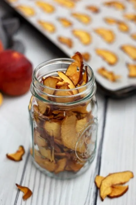 oven dried peach chips stored in a mason jar
