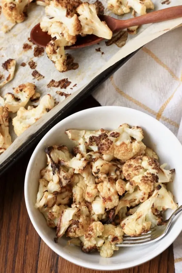 Bowl filled with roasted cauliflower coated in tahini sauce