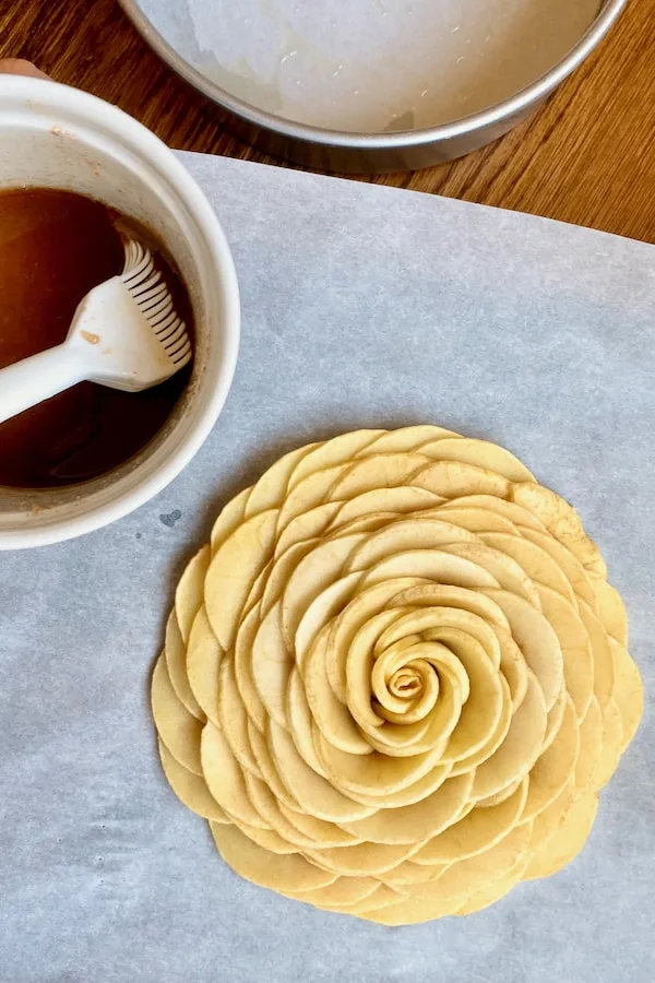 flatten apple slices to create an open flower the size of cake pan