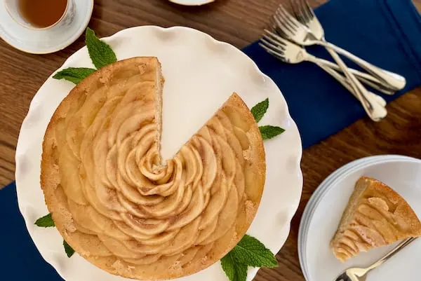 Paleo apple upside down cake served on a white cake stand