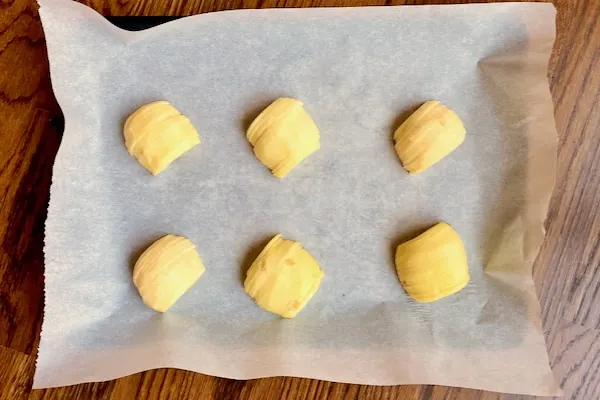 uniformly sliced apples on a parchment lined baking sheet